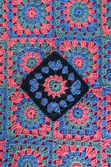 Granny square in black color as main placed on crochet afghan wi