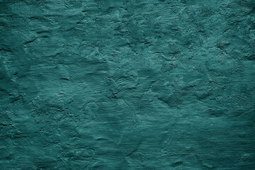 Dark green blue uneven texture. Painted old wall with plaster. Teal color. Grunge surface background for design. Rough brush strokes. Empty. Close-up.