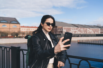 Cheerful woman taking selfie on smartphone