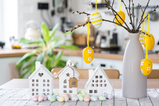 Key to house of cozy home with Easter decor with rabbit and eggs on table of kitchen. Building, design, project, moving to new house, mortgage, insurance, rent and purchase real estate