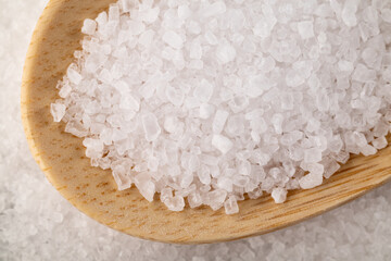 Salt on the wooden spoon. Crystals of salt macro. 