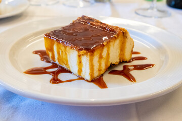 Cheese ramekin or quesada or cheesecake with icecream and chocolate coating on the dish