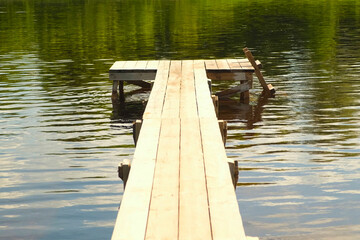 Naklejka premium Old small Wooden Pier. No People. Beautiful Empty wood dock on River. Solitude, Loneliness concept. Reflections in water. Idyllic rural scene. Pastoral landscape. Ecological resort, fishing, swimming