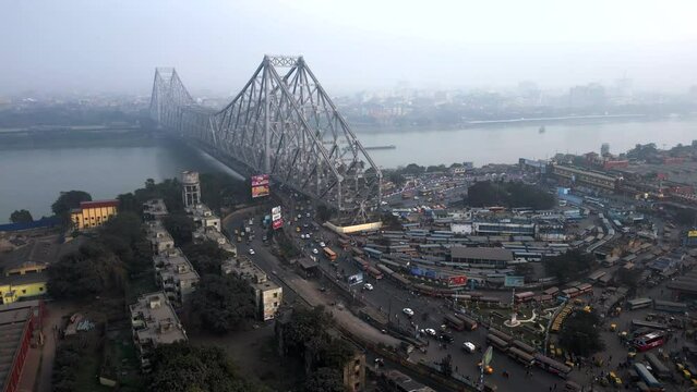 Aerial view of architectural landmark Howrah Bridge and Howrah Railway Station on a smoggy day in Kolkata, West Bengal, India. Kolkata is one of the world's most polluted cities.