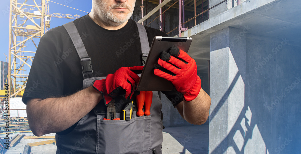 Poster man works at construction site. builder with electrical tablet. guy is on construction site. foreman