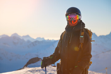 Portrait of a skier on the mountain at sunset. Portrait of a woman in a ski resort against the...