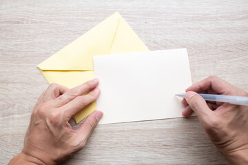 Obraz premium Male hands writing Empty cards on wooden table.