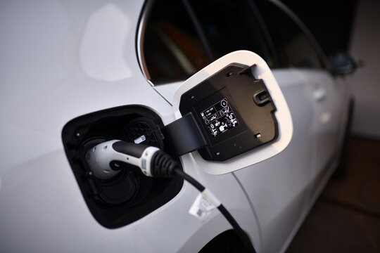 A Klasse A250 Hybrid Elektroauto beim Aufgeladen an der Tankstellen Steckdose. Solar Tanken mit Solarstrom in der Elektromobilit&auml;t. Wei&szlig;er E-Auto Ladestecker angeschlossen.