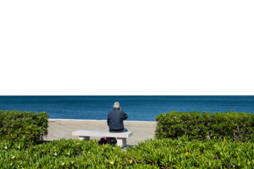  a man sitting on the bench in front of the sea on a sunny day with a transparent background