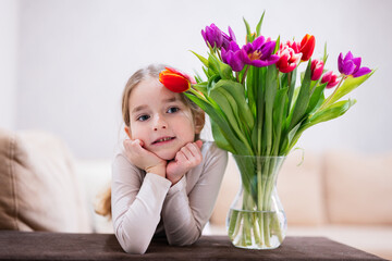 Little girl with spring tulip bouquet.  Holiday decor with flowers colorful tulips.