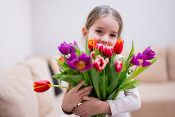 Little girl with spring tulip bouquet.  Holiday decor with flowers colorful tulips.