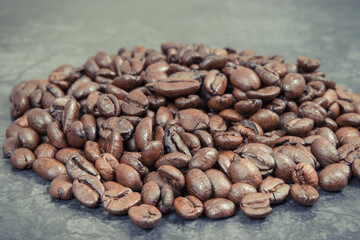 Heap of roasted fragrant coffee grains. Structure concrete