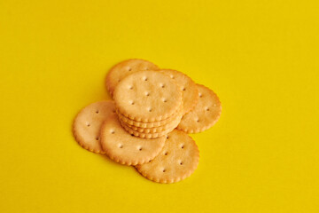 A pile of round cookies on a yellow background. A tasty and sweet snack.