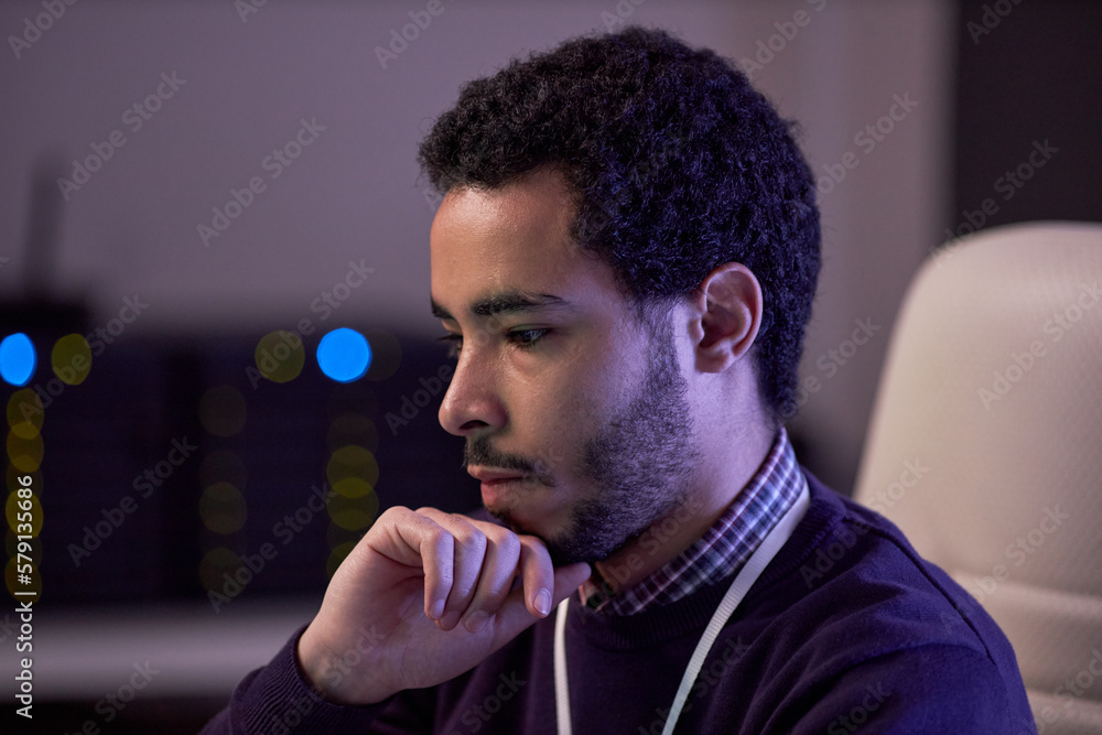 Poster side view portrait of focused man thinking while working on it project in office lit by neon light