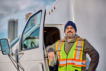 Happy professional truck driver looking at camera.