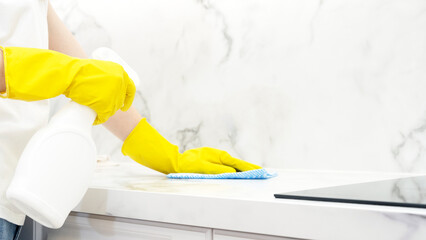 Fototapeta na wymiar Beautiful woman in protective gloves cleaning kitchen cabinet