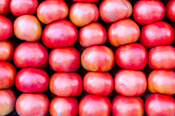 Vegetables tomatoes in the supermarket on the counter for sale.