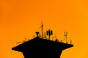 Airport Control Tower at silhouette background, radar tower plane, towering outdoor telecommunication antenna that will improve technology performance. - obrazy, fototapety, plakaty