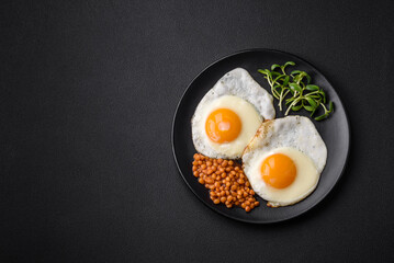 Delicious hearty breakfast consisting of two fried eggs, canned lentils and microgreens