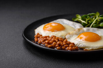 Delicious hearty breakfast consisting of two fried eggs, canned lentils and microgreens