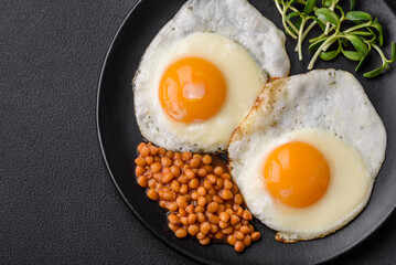 Delicious hearty breakfast consisting of two fried eggs, canned lentils and microgreens