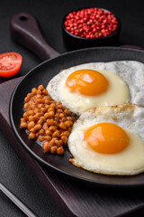 Delicious hearty breakfast consisting of two fried eggs, canned lentils and microgreens