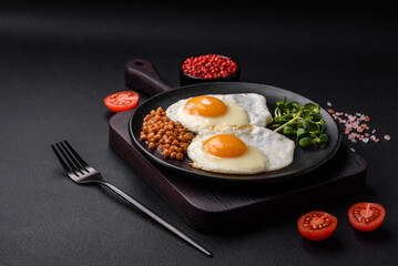 Delicious hearty breakfast consisting of two fried eggs, canned lentils and microgreens
