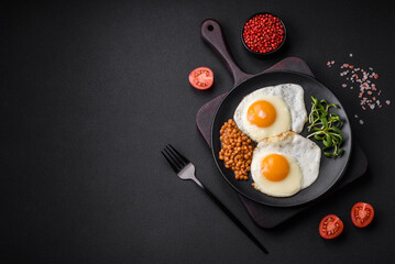 Delicious hearty breakfast consisting of two fried eggs, canned lentils and microgreens