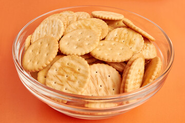 A bowl of round cookies on a yellow background. A tasty and sweet snack.