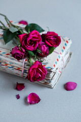 A bouquet of withered roses on a pile of letters, a symbol of lost love.