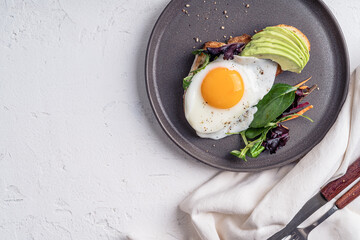 Breakfast with toasted bread, sliced avocado, and fried egg, directly above