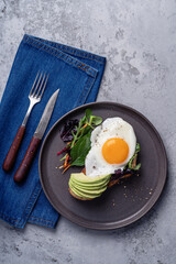 Breakfast with toasted bread, sliced avocado, and fried egg, directly above