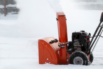 A portable snow blower powered by gasoline. Snow removal in winter.