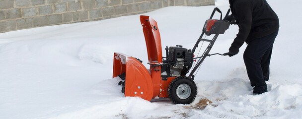 A portable snow blower powered by gasoline. Snow removal in winter.