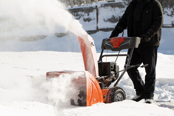 A portable snow blower powered by gasoline. Snow removal in winter.