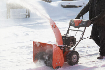 A portable snow blower powered by gasoline. Snow removal in winter.