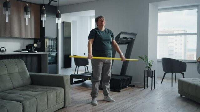 Home Fitness For Seniors, Mature Woman Doing Squats With Stick In Hands In Living Room Losing Weight