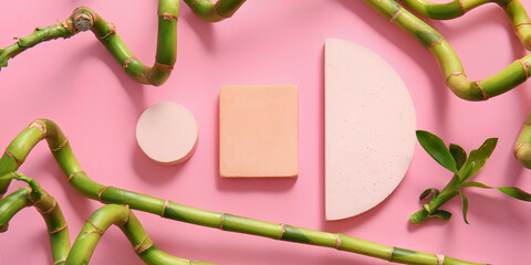Empty podiums with green bamboo branches on pink background