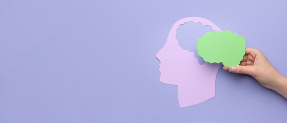 Female hand with paper human head and brain on color background with space for text. Neurology concept