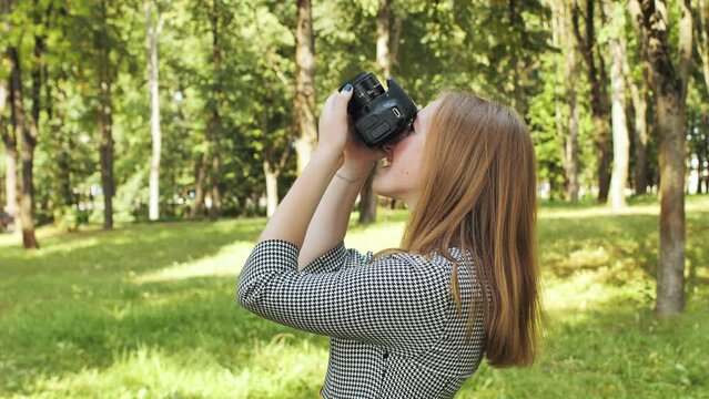 A girl taking pictures with her camera on a summer day.