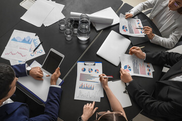 Group of people working on business plan at table in office, top view