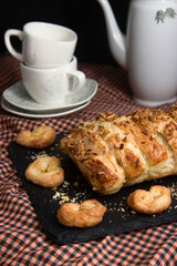 Close-up of a puff pastry next to a coffee service for two