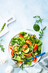 Green salad with leaves and vegetables. Top view at blue.