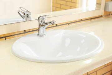 White ceramic sink on table, closeup