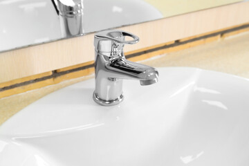 White ceramic sink on table, closeup