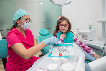 Female dentist with a young girl in her office after dental treatment