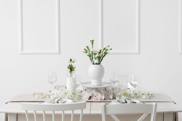 Beautiful table setting for International Women's Day celebration with eustoma and orchid flowers in light room