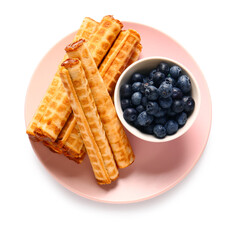 Plate of delicious wafer rolls with boiled condensed milk and blueberries isolated on white background