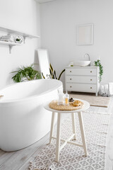 Interior of bathroom with bathtub, table and sink