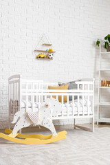 Interior of children's bedroom with crib and rocking horse